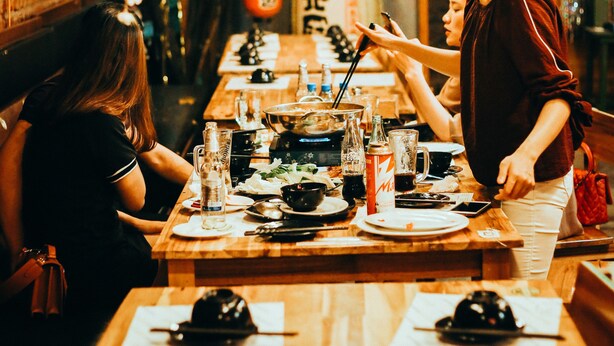 A restaurant with wooden tables, floral decorations, and a traditional Asian aesthetic. - TravelBox Dorm Sweet Dorm - Hostel (Hanoi)