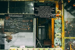 A travel box with a chalkboard map and a sign advertising hostel and dorm services. - TravelBox Dorm Sweet Dorm - Hostel (Hanoi)