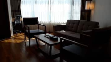 Una sala de estar moderna con un sofá, dos sillones, una mesa de centro y un escritorio con una silla.
