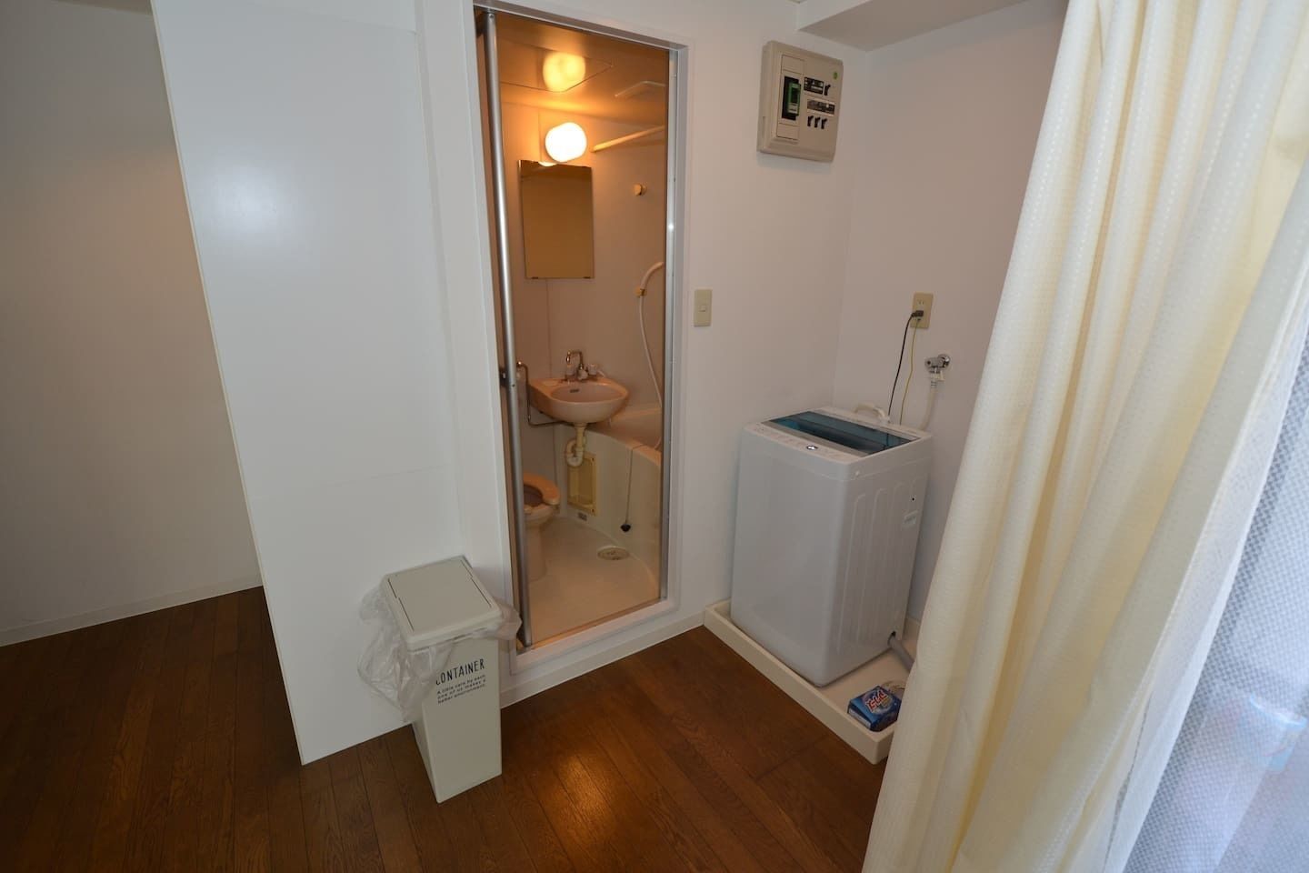 Ein kleines Badezimmer mit Toilette, Waschbecken und einer Waschmaschine.