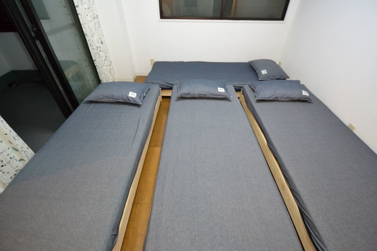 A room with a bed featuring a wooden frame and grey bedding.