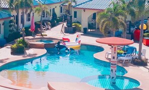 A swimming pool with multiple lanes, lounge chairs, and palm trees.