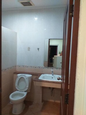 A small bathroom with a toilet, sink, and mirror.