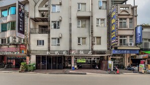 Un hotel de varios pisos con fachada moderna, balcones e indicaciones de diversos servicios y comodidades.