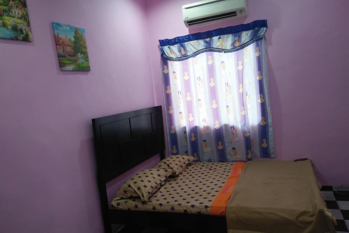 Un dormitorio con una cama individual, piso a cuadros y ventana con cortina.