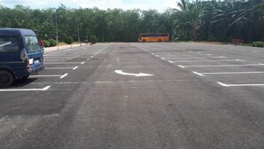 A parking lot with marked spaces and a bus in the distance. - Persatuan Kebajikan Sri Sakthi Ashram - Hostel (Tangkak)