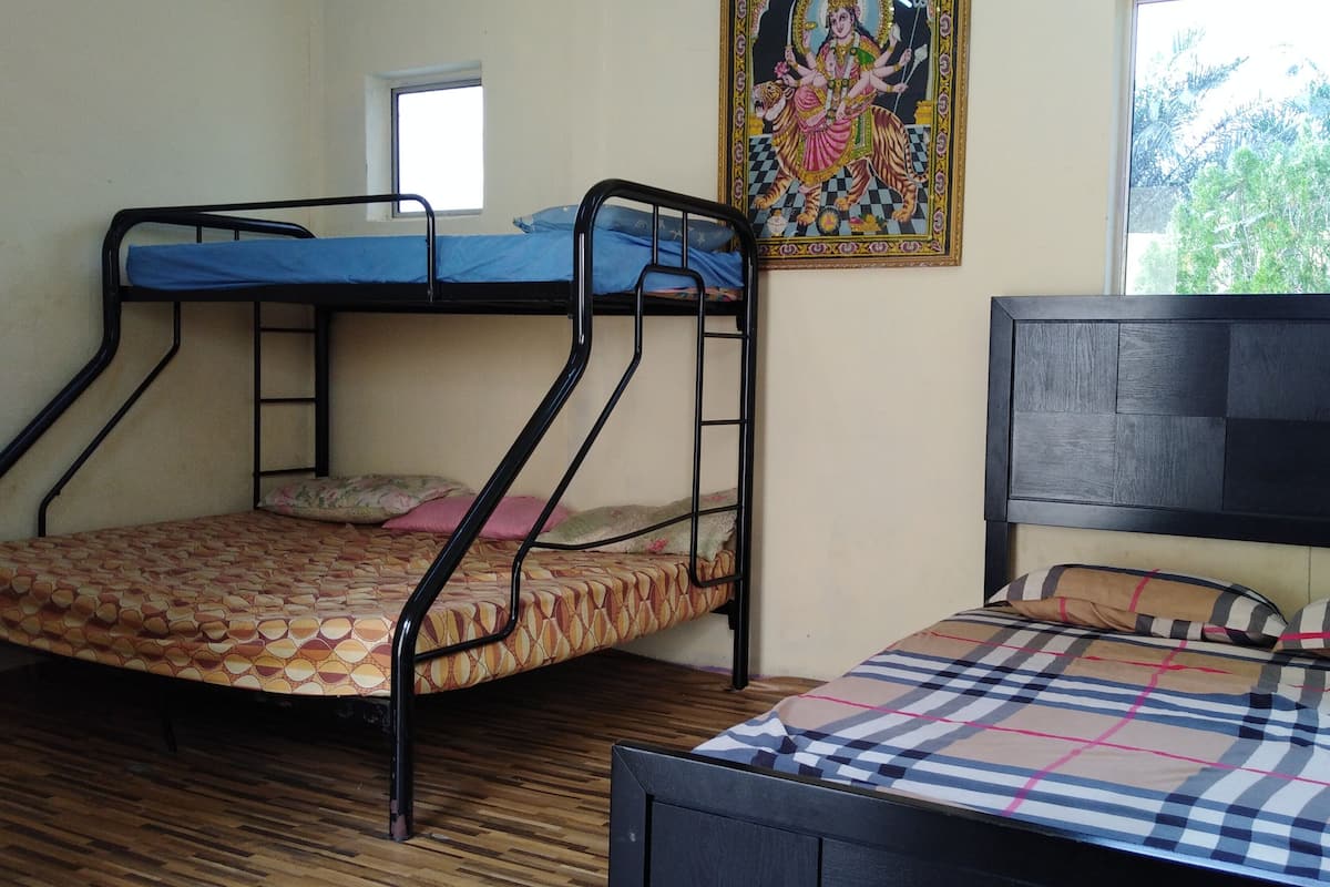 Una habitación con dos literas, una ventana y un mural en la pared.