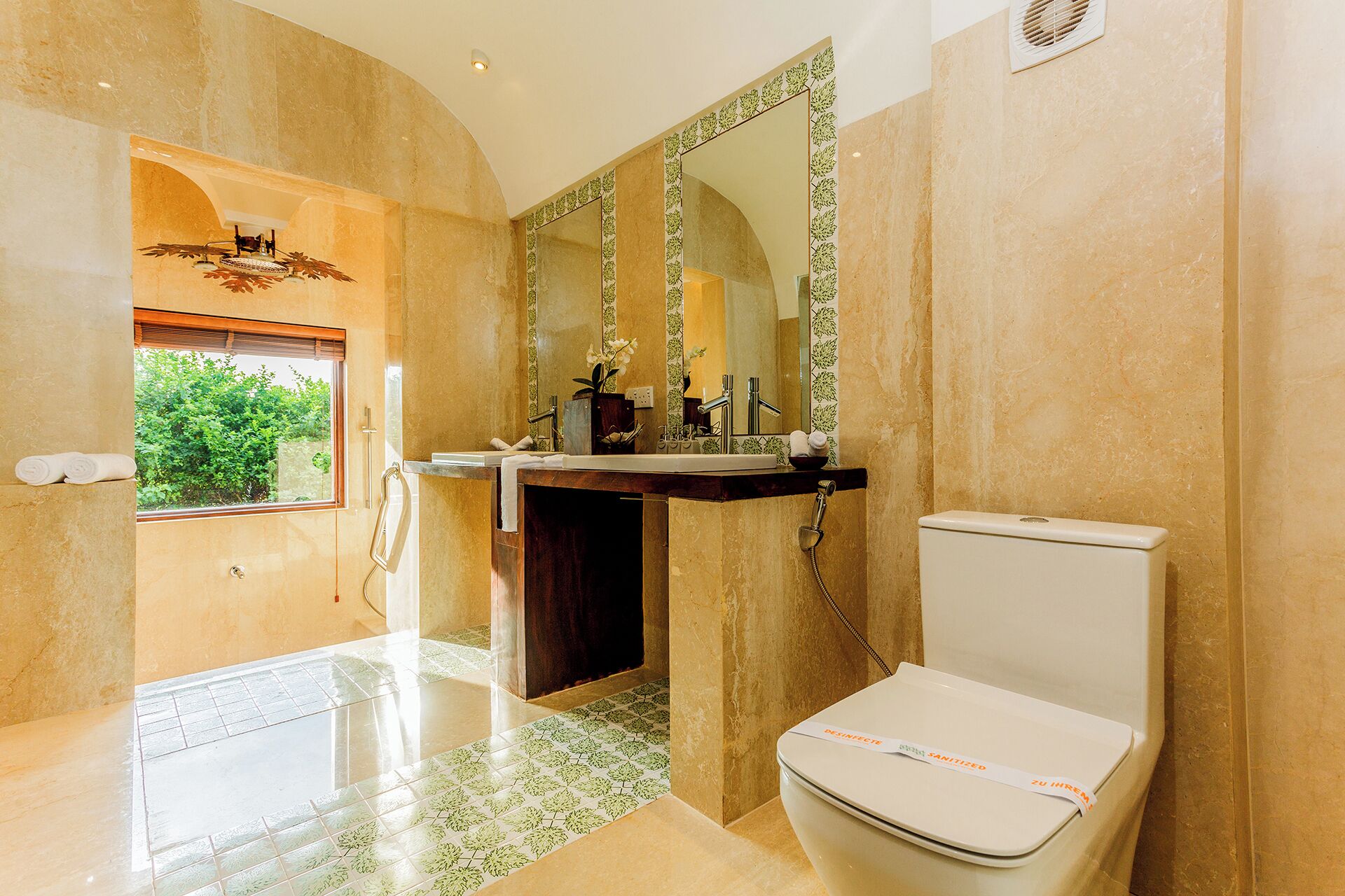 A bathroom with a large mirror, a sink, a toilet, and a shower area.