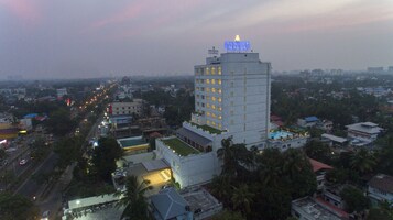 A high-rise hotel with a rooftop pool and a sign reading "MONSOON EMPIRE".