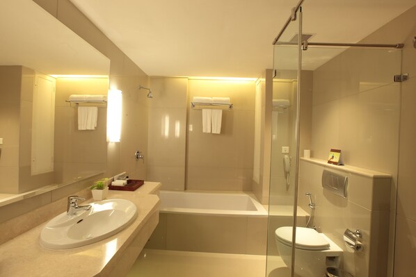 Un baño moderno con un lavamanos grande, bañera y cabina de ducha de vidrio.