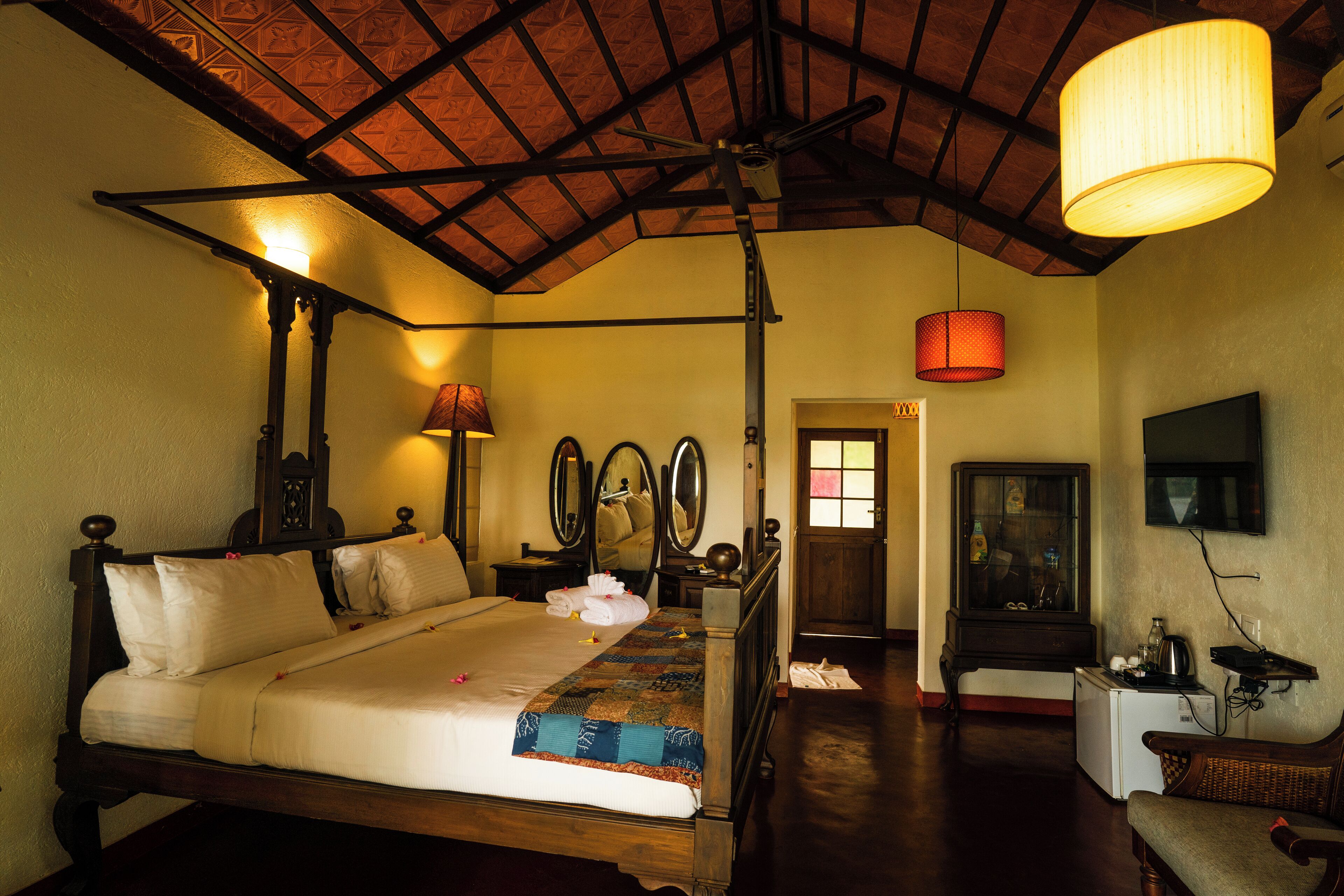 A traditional room with a wooden bed, a red hanging lamp, and a small table with a radio.