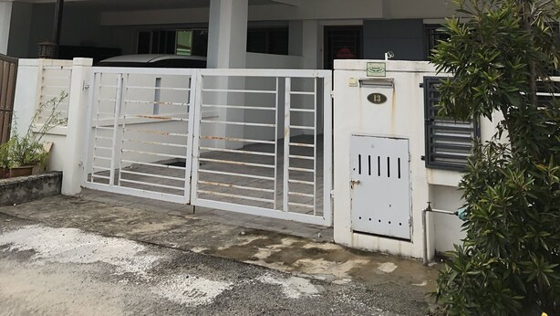 A multi-story residential building with a gated entrance, satellite dish, and a balcony.