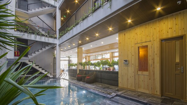 A multi-level indoor pool area with a wooden wall and a staircase. - King House Villa Hotel (Da Nang)