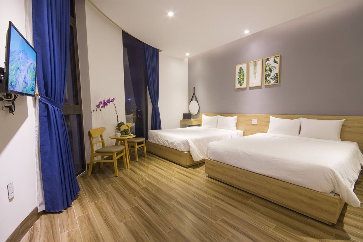 Una habitación de hotel con dos camas, un escritorio y una silla.