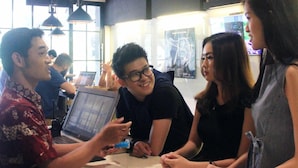 A group of people sitting around a table with laptops, engaged in a discussion. - My Studio Hotels Kualanamu Airport Medan (Medan)