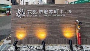 A sign for the Floral Hotel Sakaisuji-Honmachi with a brick facade and two security cameras. - Floral Hotel · SakaisuJi-Honmachi Osaka (Osaka)