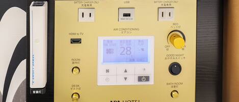A control panel with a digital display, USB port, and various buttons for room and desk lighting, air conditioning, and a good night mode.