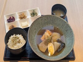 A traditional Japanese meal with rice, fish, and pickled vegetables on a tray.
