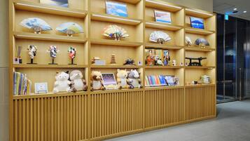 Una exhibición de madera con diversos artículos, como libros, peluches y abanicos decorativos.