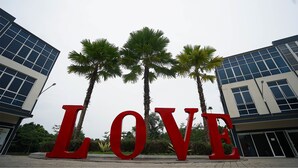 A building with the word "LOVE" in large red letters, surrounded by palm trees. - The Lively Hotel Kualanamu Airport Medan (Medan)
