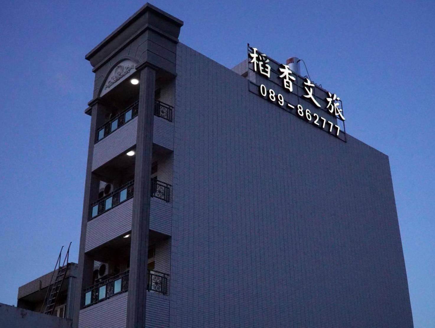 A building with a sign indicating a business name and contact number.
