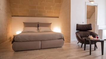 A bedroom with a bed, a chair, and a table.