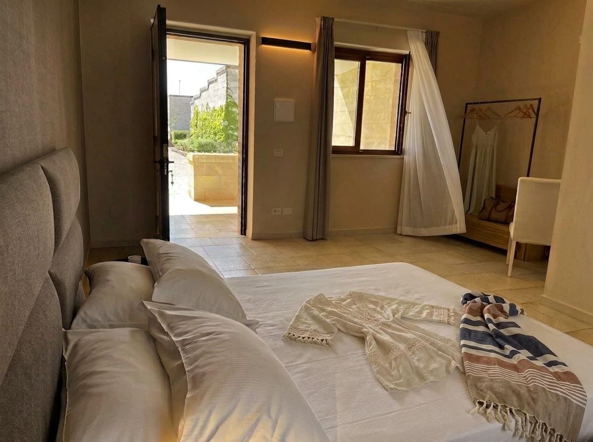 A bedroom with a bed, a window, and a view of the outside.