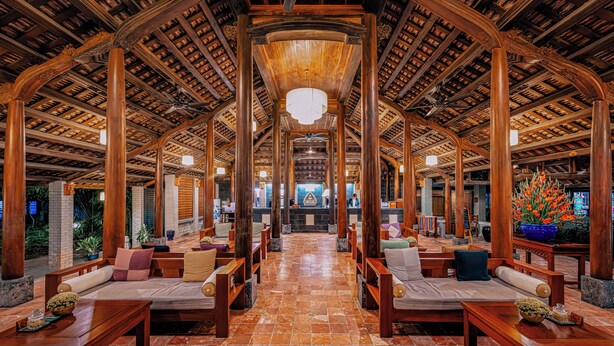 A spacious lobby with wooden furniture, a tiled floor, and a high wooden ceiling. - Pilgrimage Wellness Retreat – part of Pilgrimage Village Resort & Spa (Hue)