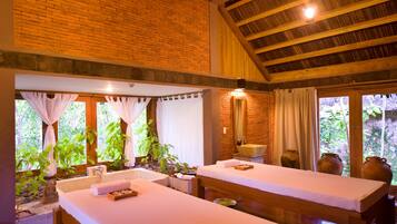 Relax in a serene spa room with a brick wall, wooden beams, and lush views.