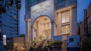 Entrada del Hotel Grand Central con un diseño moderno, destacando un arco prominente y una escalera que conduce a la recepción.