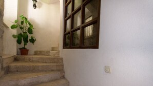 A staircase with a potted plant, a window with multiple panes, and a light switch on the wall. - Top floor apartment (Trogir)