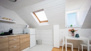 A compact kitchen with white cabinets, a wooden countertop, and a skylight. - Top floor apartment (Trogir)