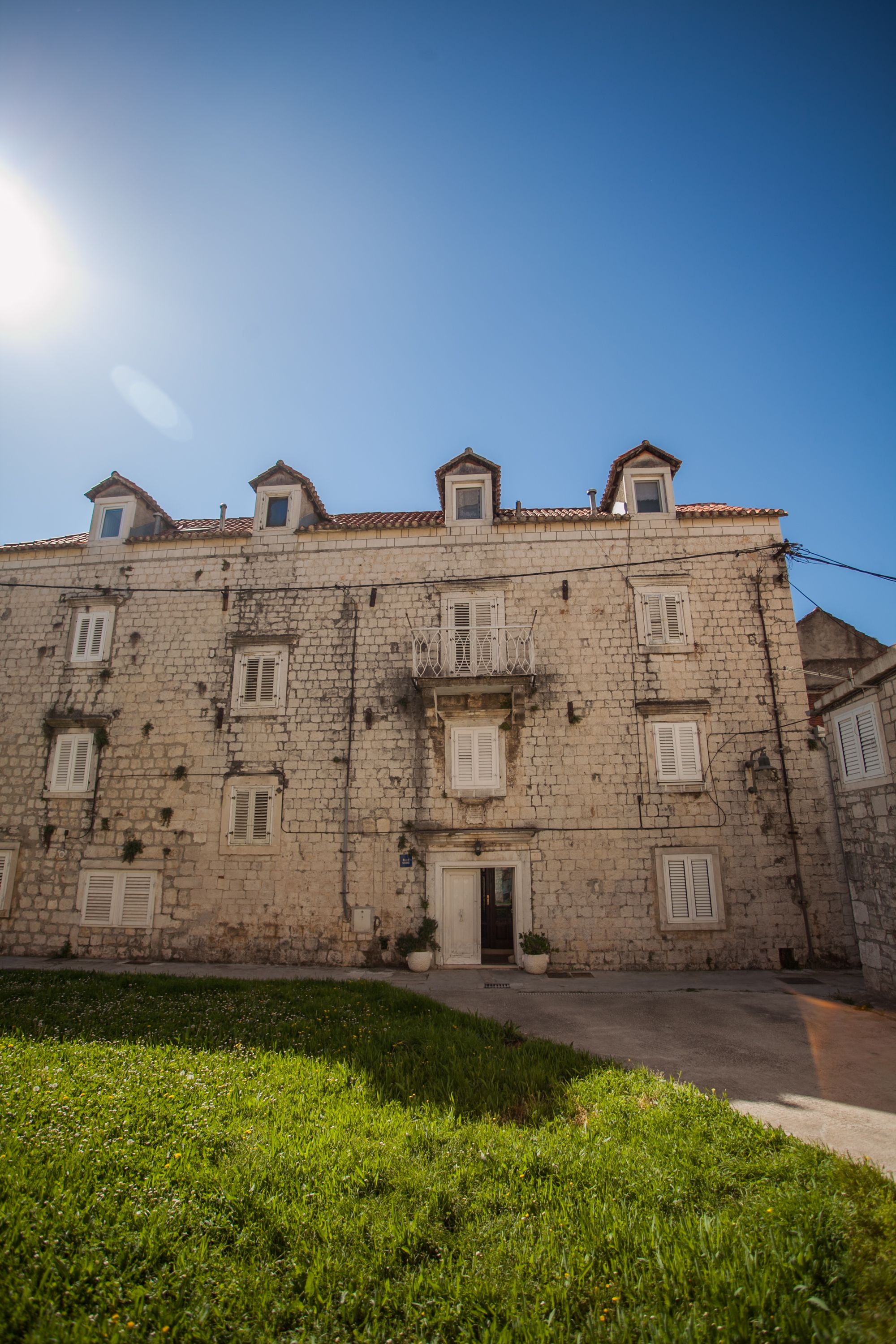 A historic stone building with multiple windows and a central entrance.