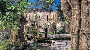 A rustic stone pathway leading to a wooden structure with a staircase.