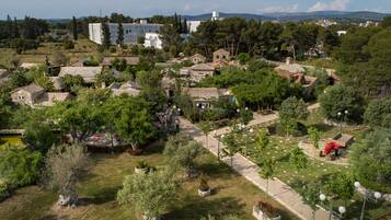 A village with traditional stone buildings, narrow pathways, and lush greenery.