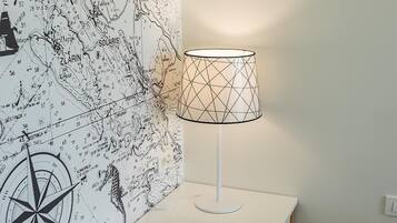 Une table blanche, une lampe et un papier peint représentant une carte.