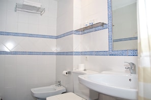 A bathroom with a bidet, a sink, and a mirror. - Hotel Reino Nevado (Monachil)