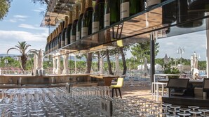 Eine Bar mit Weinkühler, Tischen und Stühlen.
