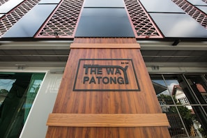 A wooden sign with "THE WAY PATONG" and a date "06/26".