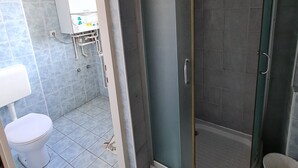 Un baño con ducha, inodoro y lavamanos.