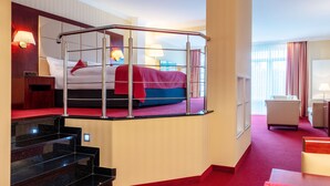 A hotel room with a bunk bed, a desk, a chair, a lamp, and a window with curtains. - Hotel Amaris Bremerhaven (Bremerhaven)