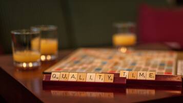 Un juego de Scrabble sobre una mesa de madera con vasos de jugo de naranja.