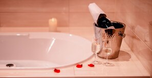 A bathtub with a champagne bottle and glasses. - Hotel Amaris (Bremerhaven)