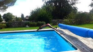 Una piscina al aire libre de temporada, sombrillas, tumbonas