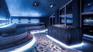 Un intérieur moderne avec un espace salon aux lignes courbes, un comptoir d’accueil et de grandes fenêtres.
