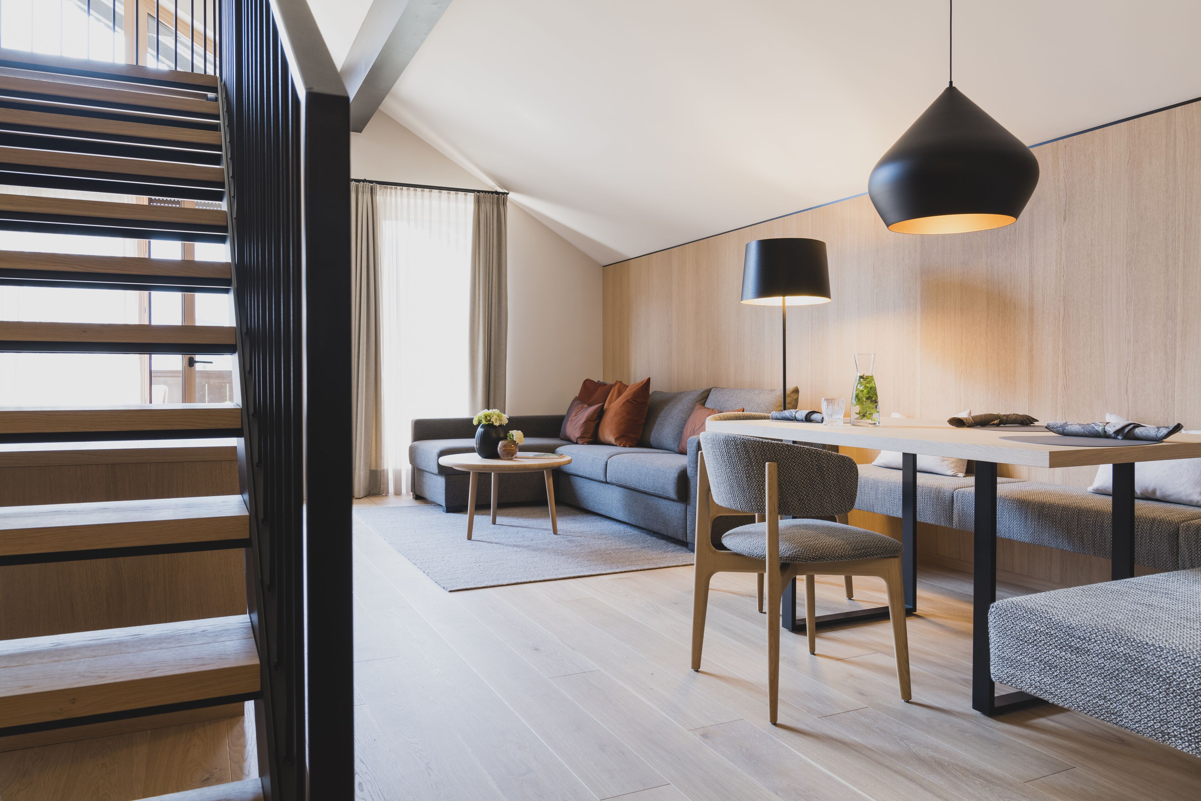 Ein modernes Wohnzimmer mit Sofa, Couchtisch und Essbereich.