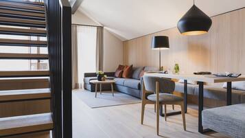 Ein modernes Wohnzimmer mit Sofa, Couchtisch und Essbereich.