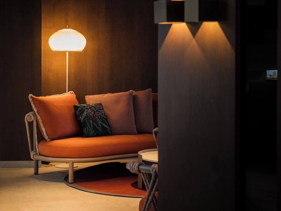 Ein modernes Wohnzimmer mit einer Couch, einer Stehlampe und einer Wandleuchte.