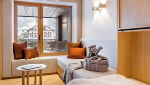 Une pièce confortable avec un lit, une petite table et une fenêtre donnant sur des immeubles.