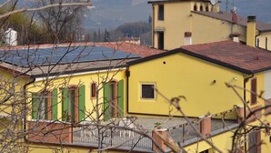 A yellow building with green shutters, a small window, and a balcony with a metal railing. - B&B Corte Galo (Tregnago)